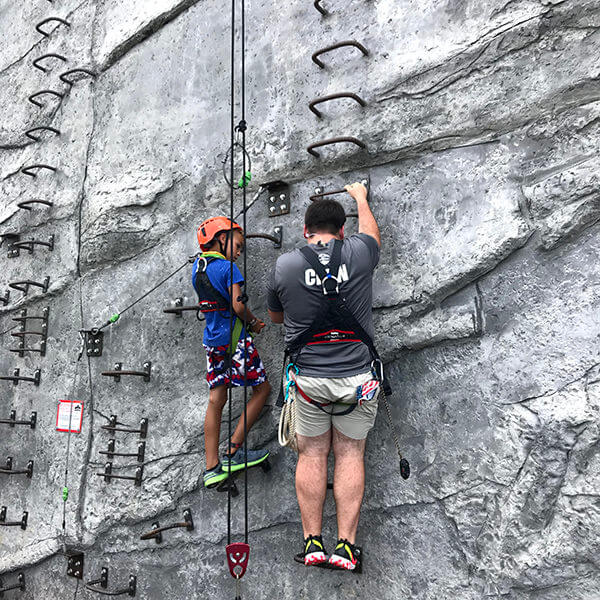 family helping family climb wall